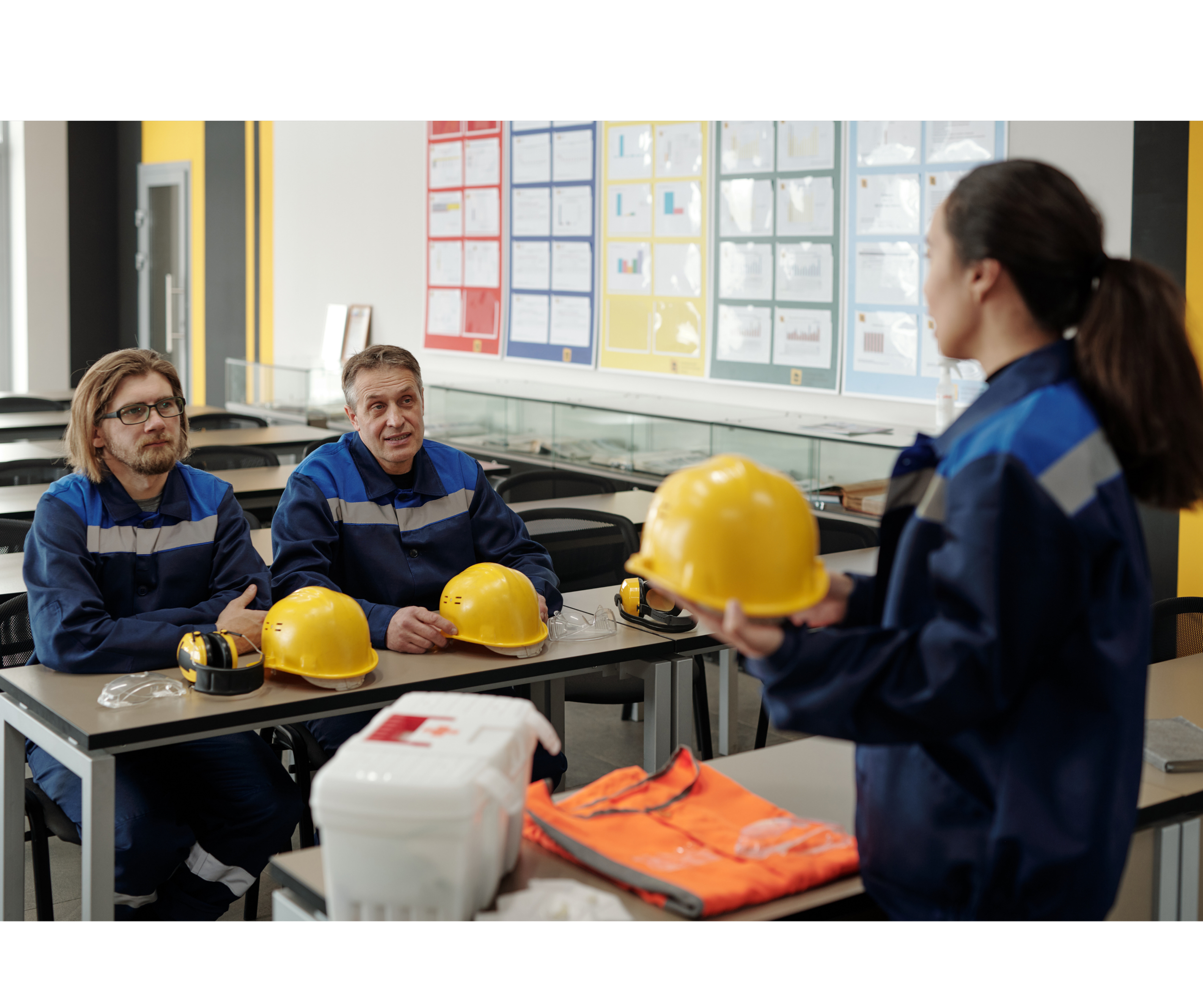Workers discussing safety gear in training session.